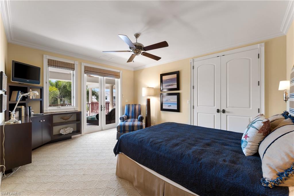 590 17th Avenue South Naples, FL 34102 - Photo 32 of 50 a spacious bedroom with a bed and wooden floor