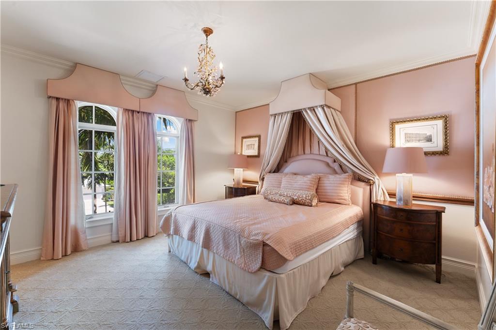 590 17th Avenue South Naples, FL 34102 - Photo 36 of 50 a bedroom with a large bed and a chandelier