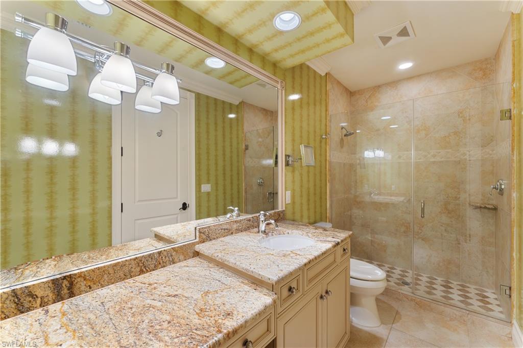 590 17th Avenue South Naples, FL 34102 - Photo 41 of 50 a bathroom with a granite countertop sink a toilet and shower