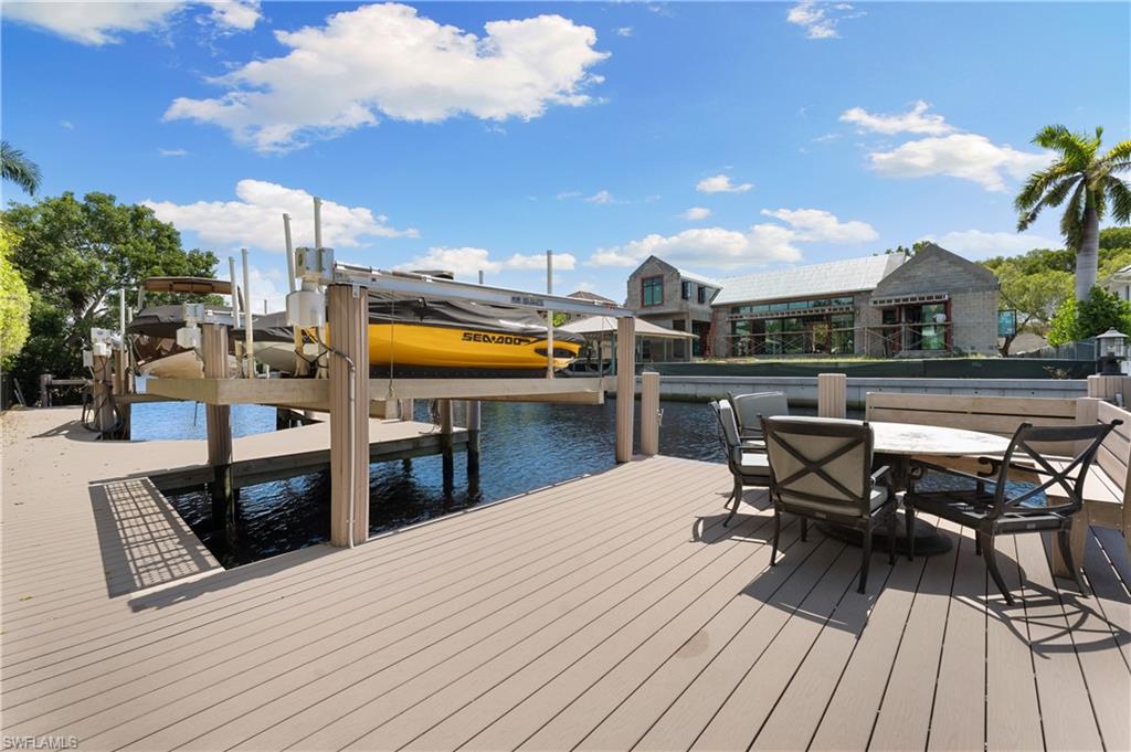 590 17th Avenue South Naples, FL 34102 - Photo 50 of 50 a view of a patio with table and chairs with wooden floor and fence