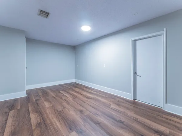 a view of empty room with wooden floor