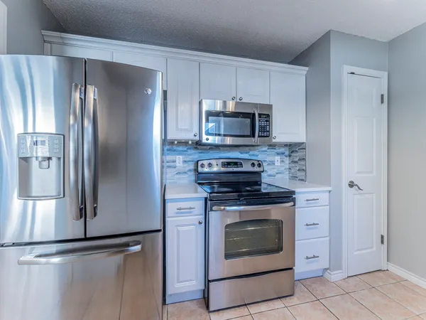a kitchen with stainless steel appliances a refrigerator stove and microwave
