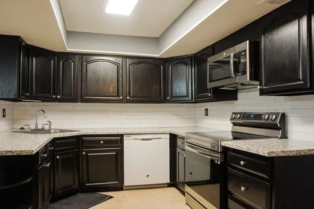 a kitchen with a sink stove and microwave