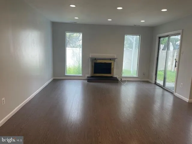an empty room with wooden floor and a fireplace
