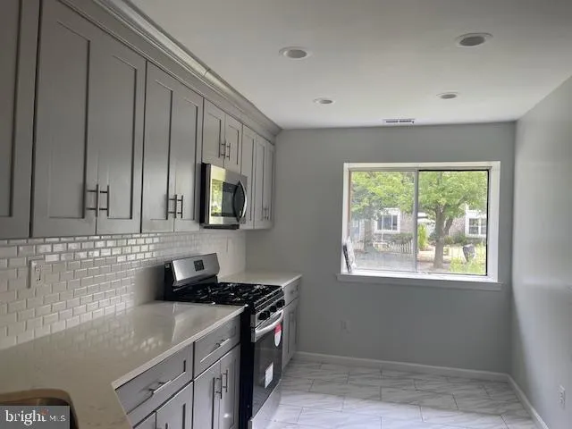 a kitchen that has a sink and a stove in it