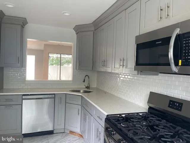 a kitchen with granite countertop a sink a stove and cabinets