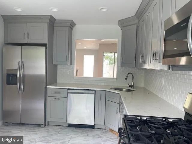 a kitchen with stainless steel appliances granite countertop a sink and a refrigerator