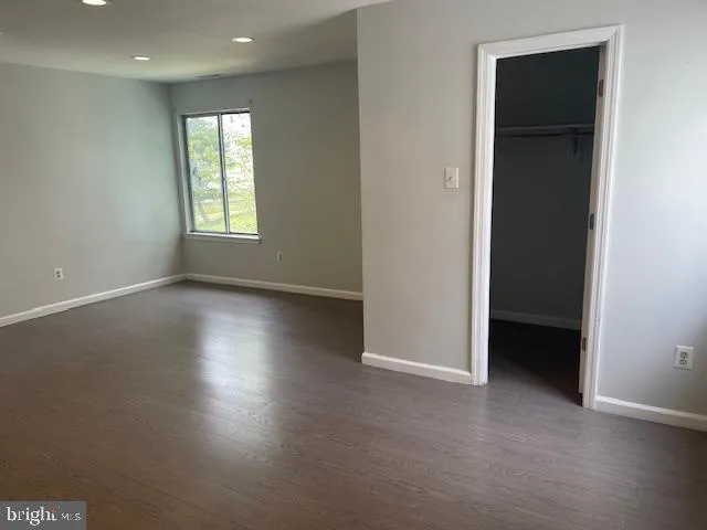 an empty room with wooden floor and closet