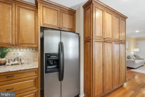 a kitchen with stainless steel appliances granite countertop a refrigerator a stove and a sink with wooden floor