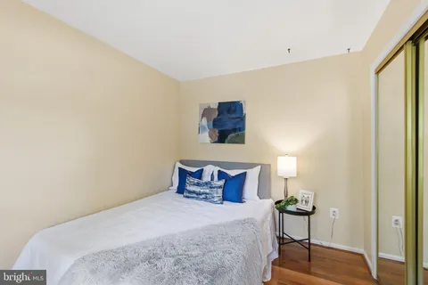 a bedroom with a bed a mirror and a window