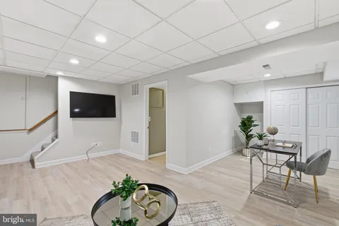a view of a backyard with large trees and wooden fence