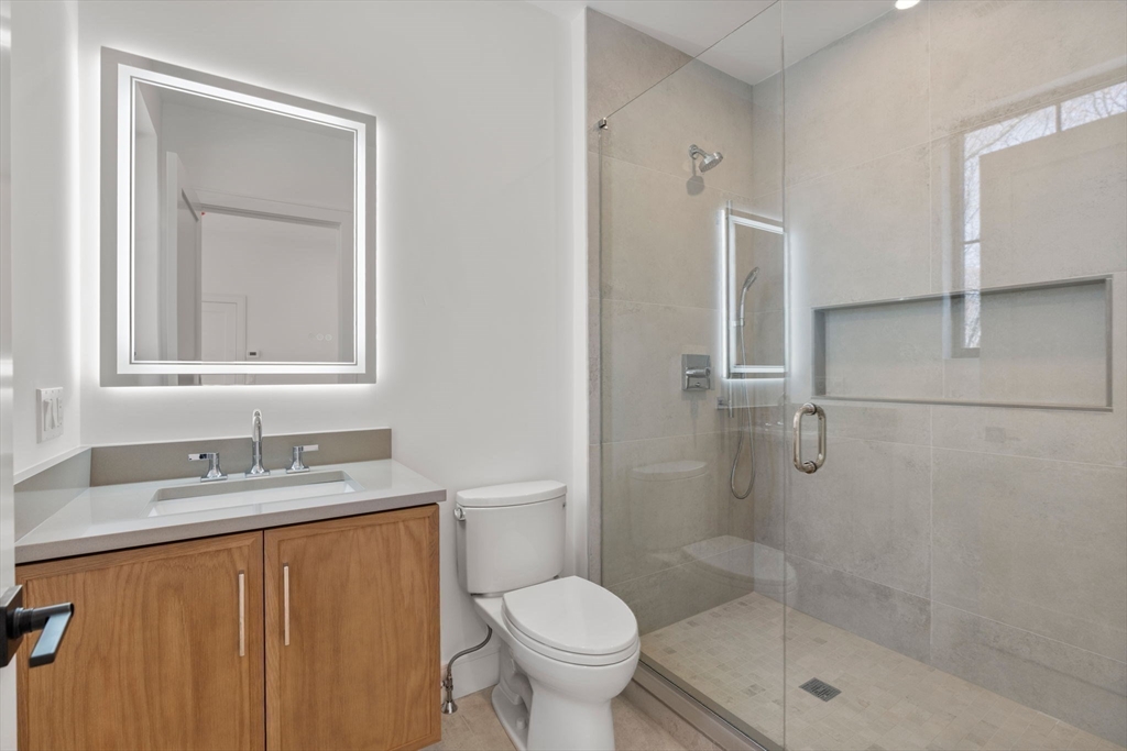470 Quinobequin Road Newton, MA 02468 - Photo 28 of 37 a bathroom with a granite countertop sink toilet and shower