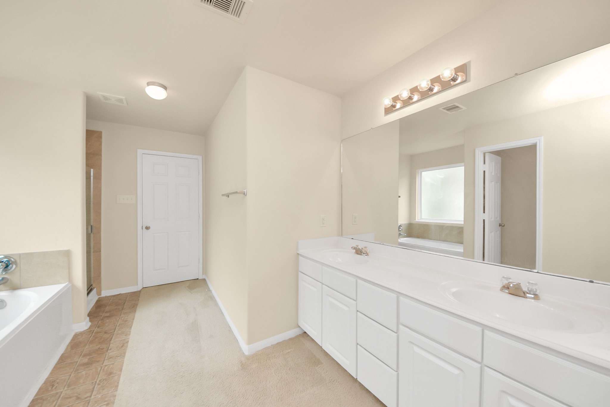 15623 Sheldon Ridge Way Houston, TX 77044 - Photo 16 of 36 a spacious bathroom with a double vanity sink a mirror and a bathtub