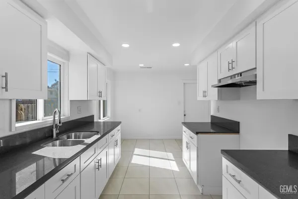 a kitchen with granite countertop a sink and a stove top oven