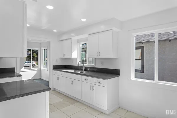 a kitchen with granite countertop white cabinets and white appliances