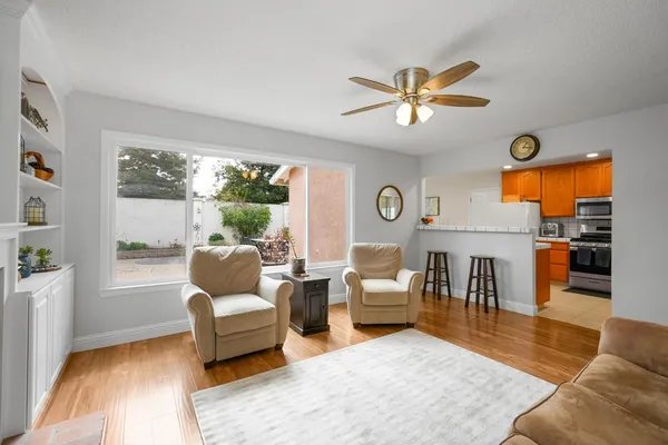 a kitchen with stainless steel appliances granite countertop a stove top oven a sink dishwasher and white cabinets with wooden floor