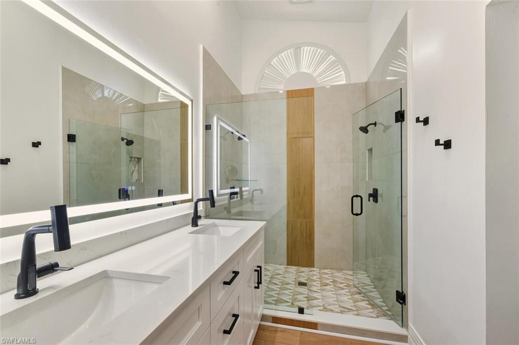 401 Countryside Drive Naples, FL 34104 - Photo 18 of 30 a bathroom with a tub sink and mirror