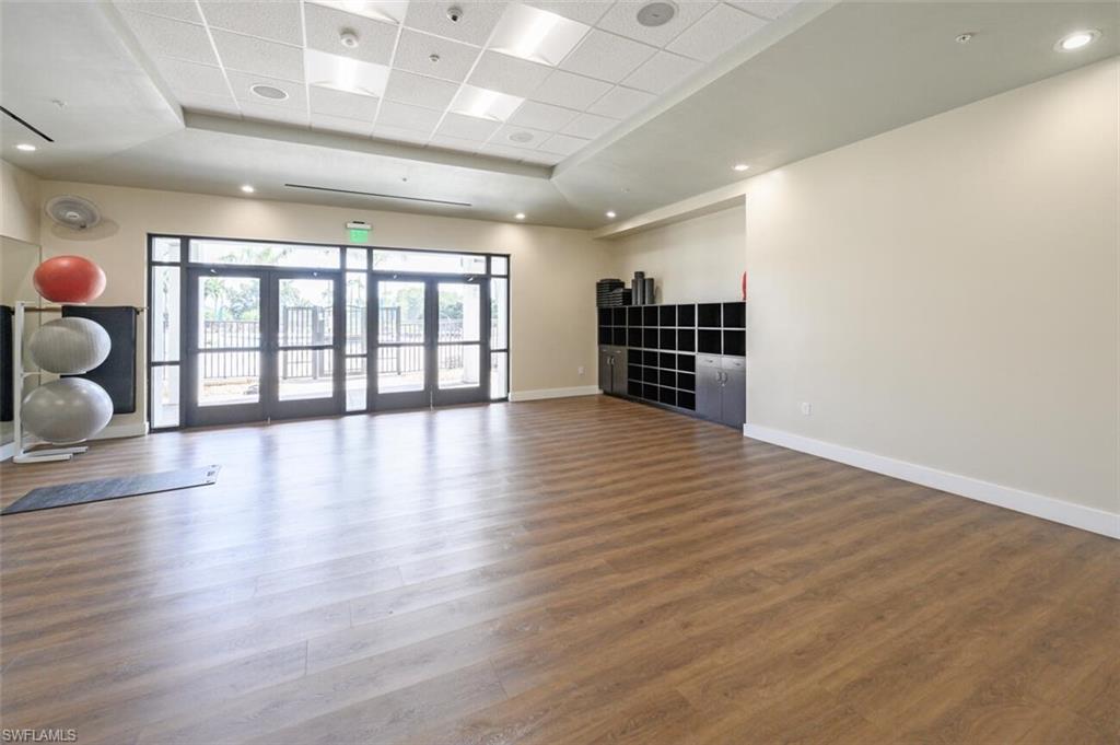 401 Countryside Drive Naples, FL 34104 - Photo 28 of 30 an empty room with wooden floor and windows