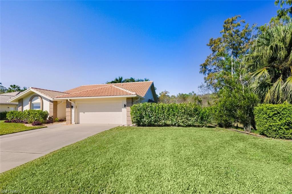 401 Countryside Drive Naples, FL 34104 - Photo 3 of 30 a front view of a house with a yard and garage