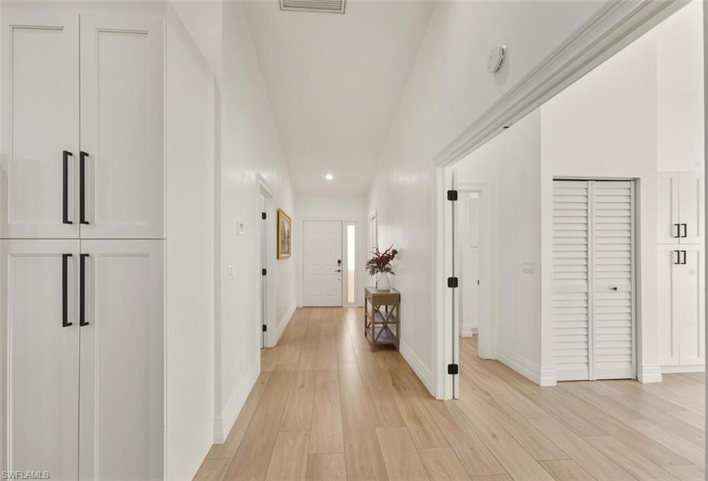 401 Countryside Drive Naples, FL 34104 - Photo 4 of 30 a view of a hallway with wooden floor and staircase