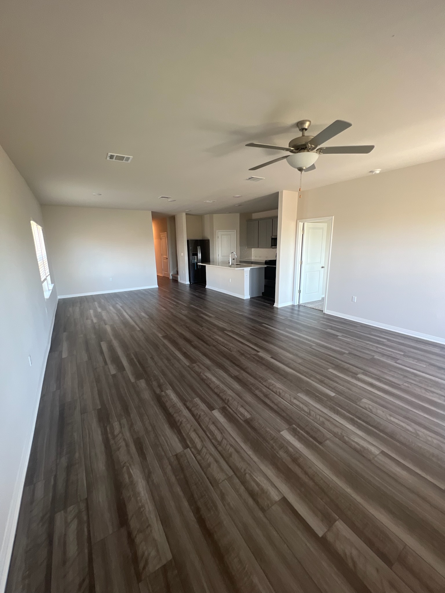6400 Rounded Pebble Lane Buda, TX 78610 - Photo 29 of 34 a view of an empty room with wooden floor and a ceiling fan