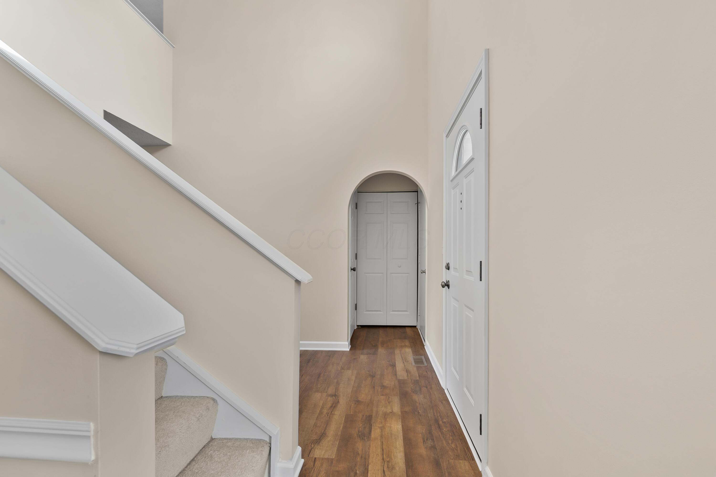 30 Tabilore Loop Delaware, OH 43015 - Photo 7 of 55 • New luxury vinyl plank flooring ~ 2025 • Tan painted walls • Two-story ceiling • Chandelier • Coat closet with bi-fold doors