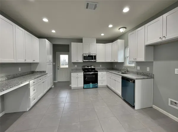 a kitchen with granite countertop cabinets and white appliances