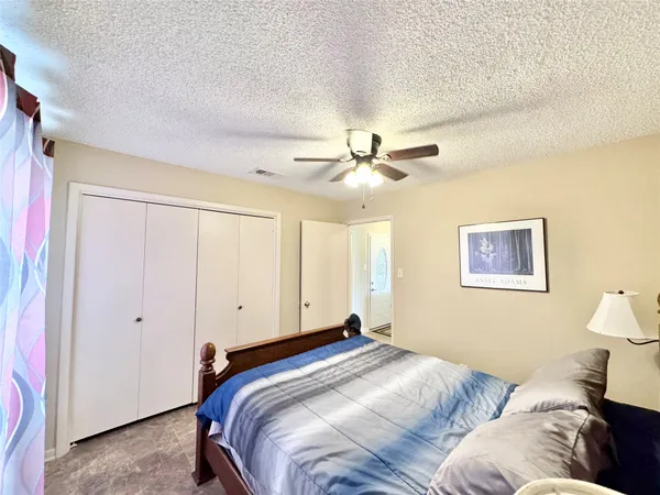 a bedroom with a large bed and a ceiling fan