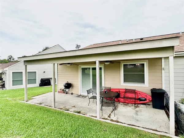 a view of a house with a patio and a yard