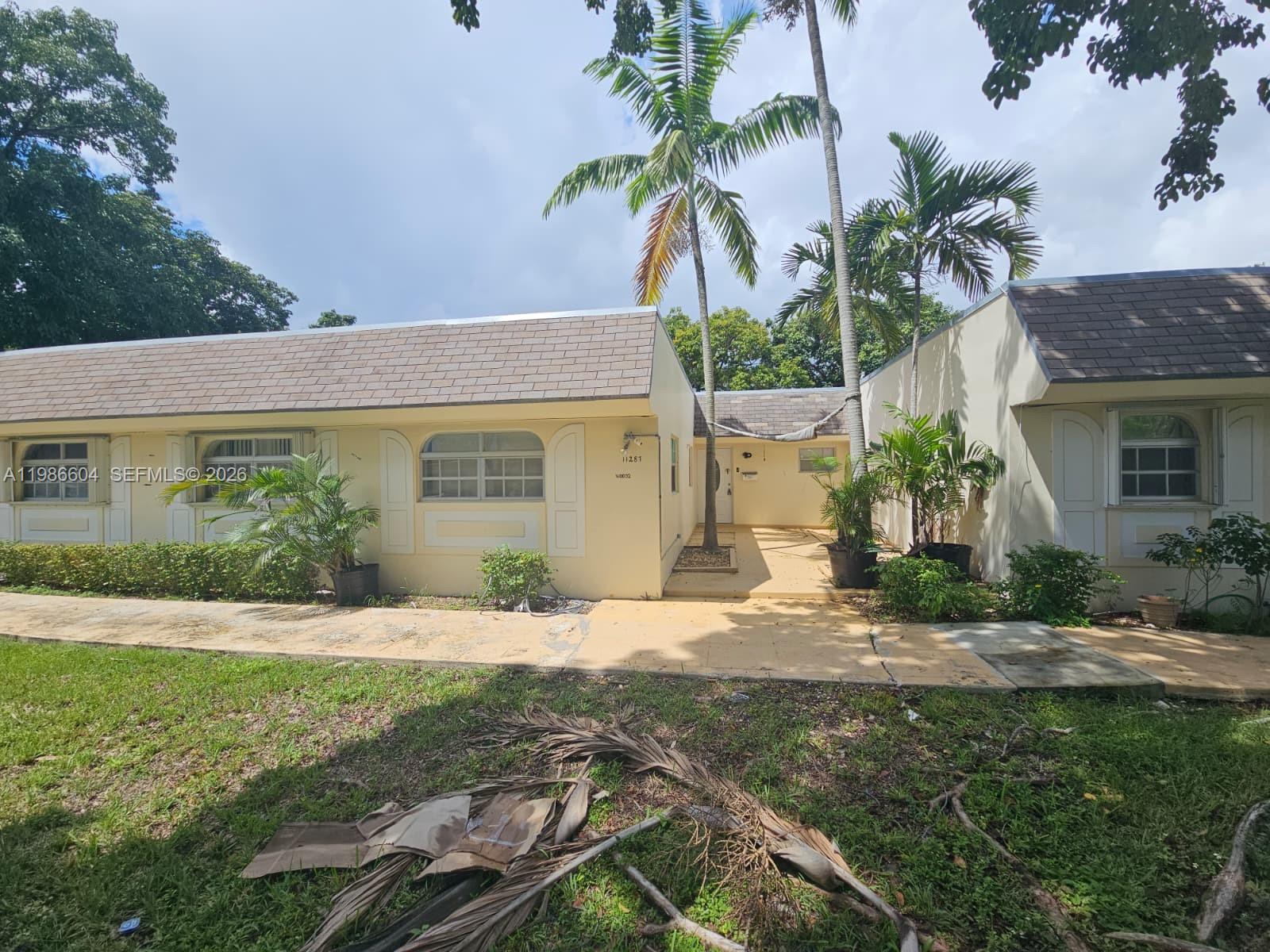 11287 Southwest 169th Street, Unit V41032 Miami, FL 33157 - Photo 2 of 14 a front view of a house with a yard and garage
