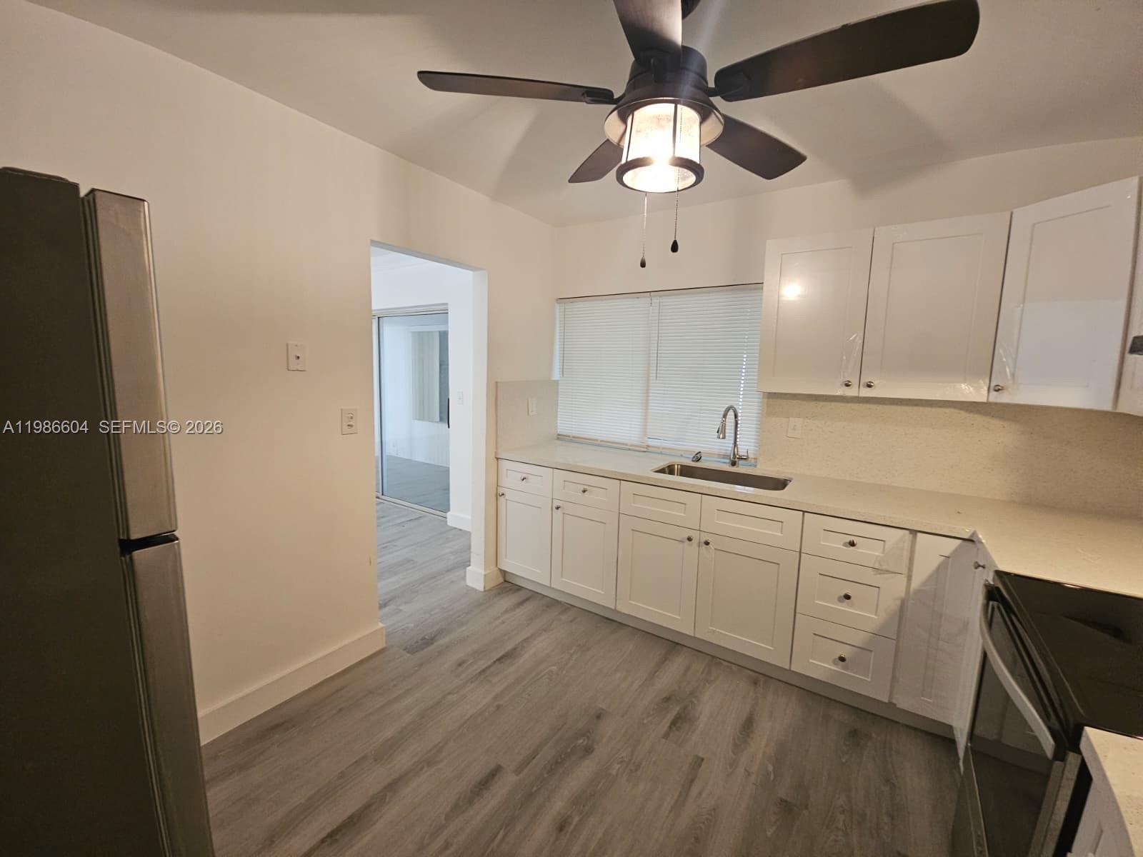 11287 Southwest 169th Street, Unit V41032 Miami, FL 33157 - Photo 7 of 14 a kitchen with cabinets a sink and appliances