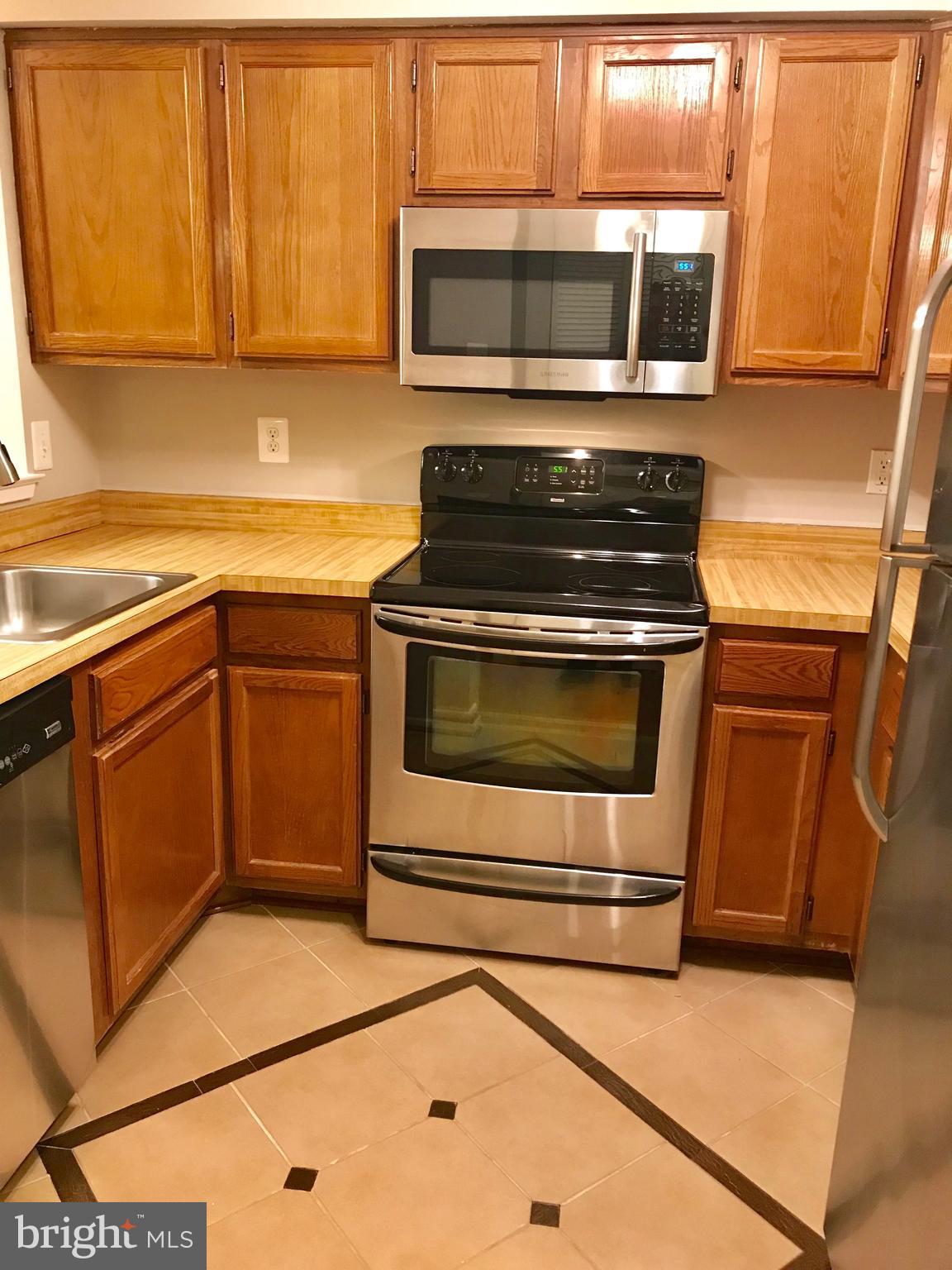 7702 Lexton Place, Unit 65 Springfield, VA 22152 - Photo 9 of 24 a kitchen with stainless steel appliances granite countertop a stove microwave and sink