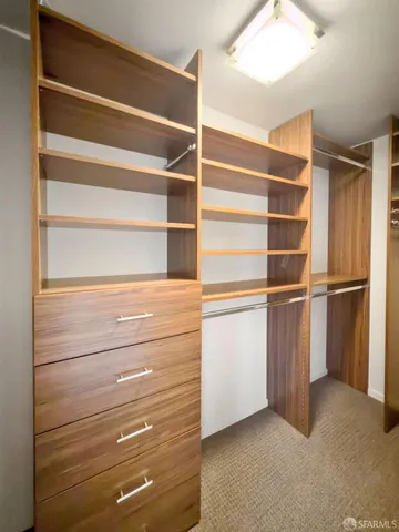 a view of walk in closet with empty racks