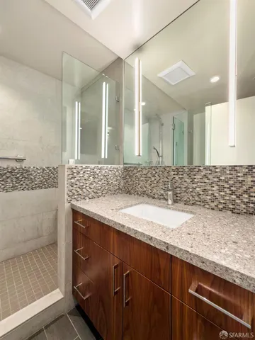 a bathroom with a granite countertop sink and a mirror