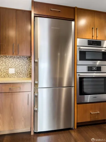 a metallic refrigerator freezer sitting in a kitchen