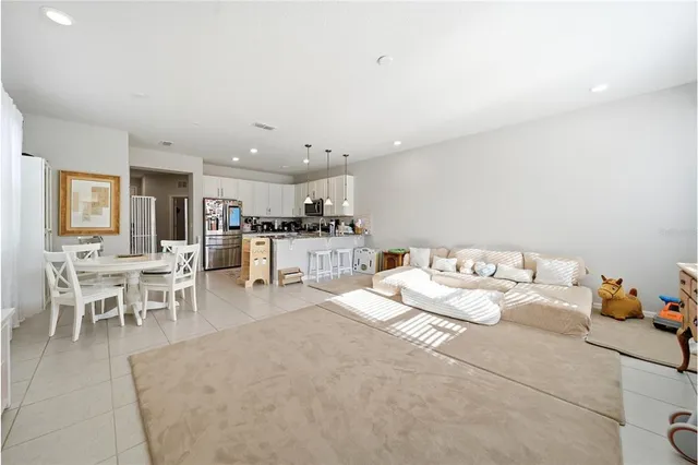 a living room with furniture and a dining table with kitchen view