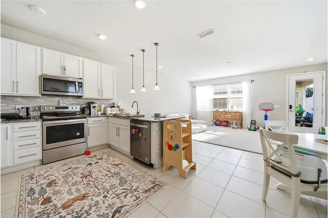 a kitchen with stainless steel appliances kitchen island granite countertop a sink counter top space and cabinets