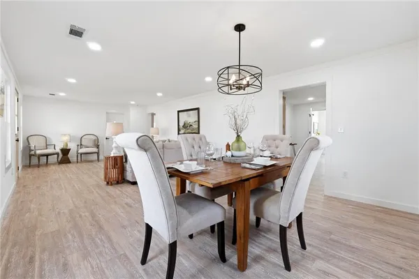 a view of a dining room with furniture wooden floor and chandelier