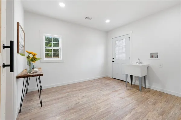 a view of an empty room with a window and wooden floor