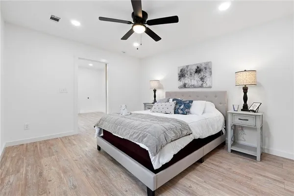 a spacious bedroom with a bed and a chandelier