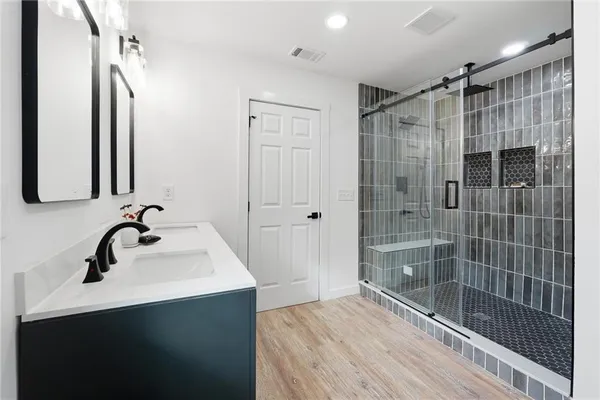 a bathroom with a shower sink and mirror