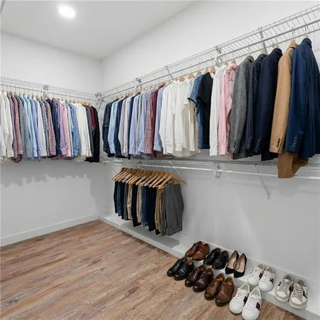 a view of walk in closet with clothes and shoes
