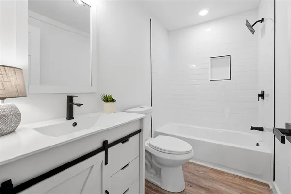 a bathroom with a sink a toilet and shower