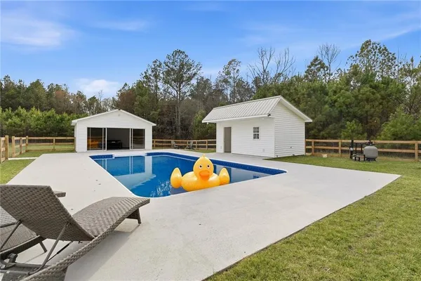 a view of a house with swimming pool and sitting area