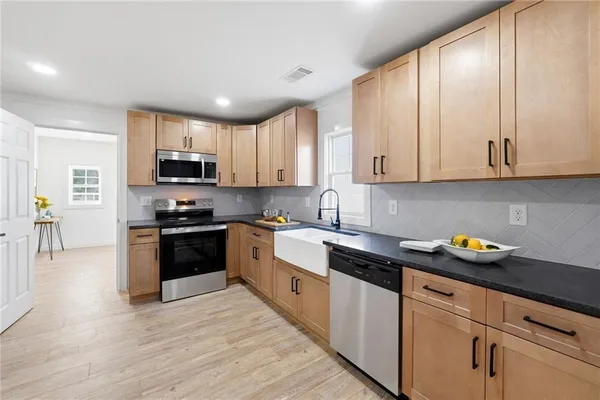 a kitchen with granite countertop white cabinets and stainless steel appliances