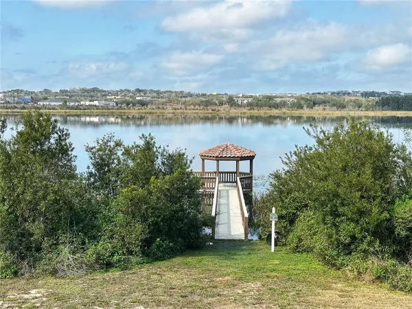 a view of a lake with a big yard and large trees
