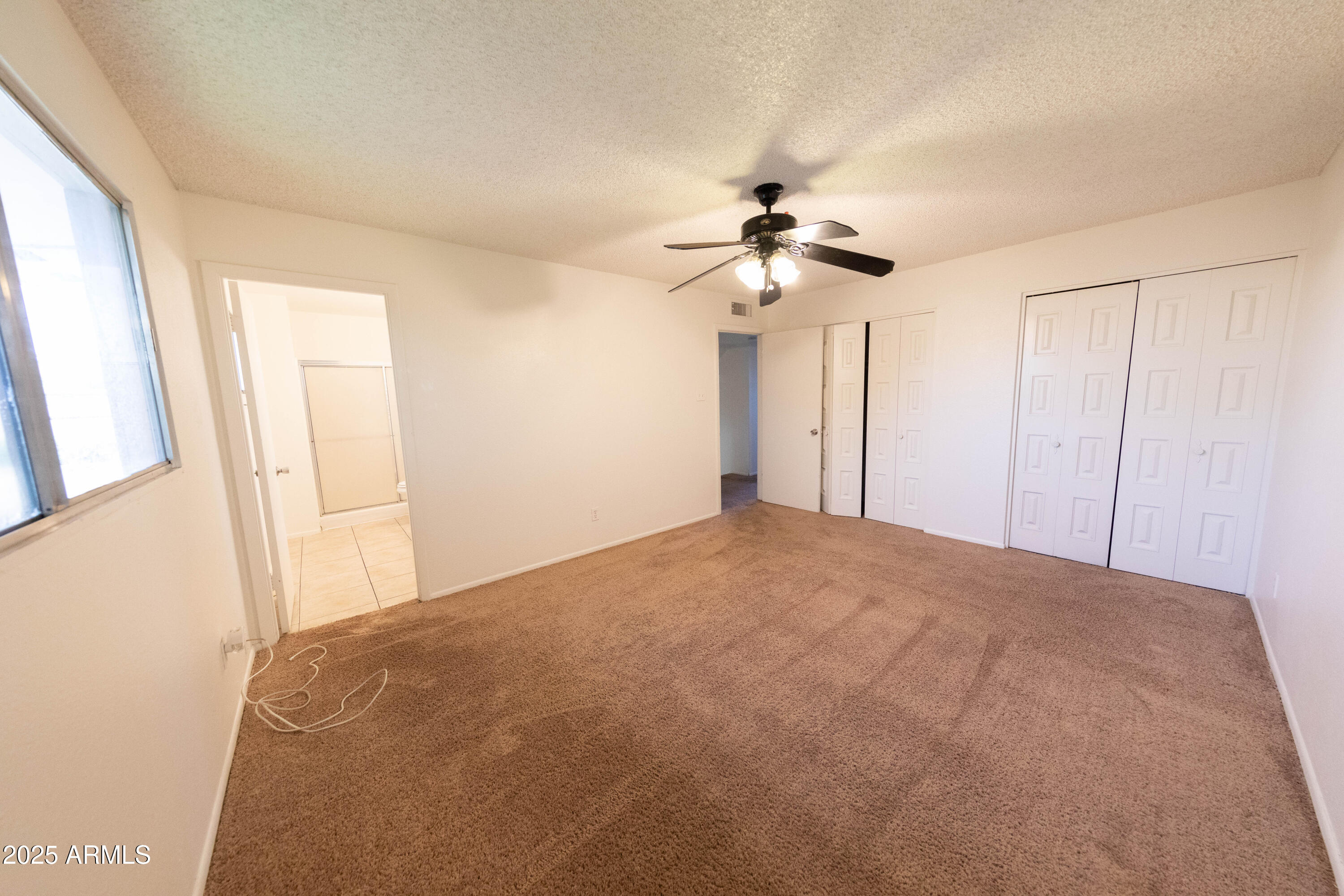 1349 East Donner Drive Tempe, AZ 85282 - Photo 17 of 26 a view of a big room with closet and a ceiling fan