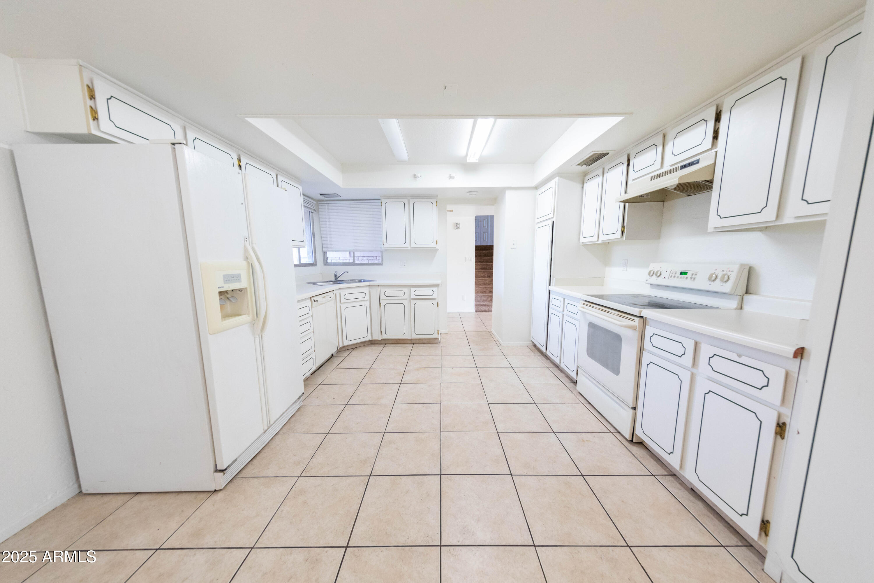 1349 East Donner Drive Tempe, AZ 85282 - Photo 3 of 26 a kitchen with white cabinets a sink stove and refrigerator