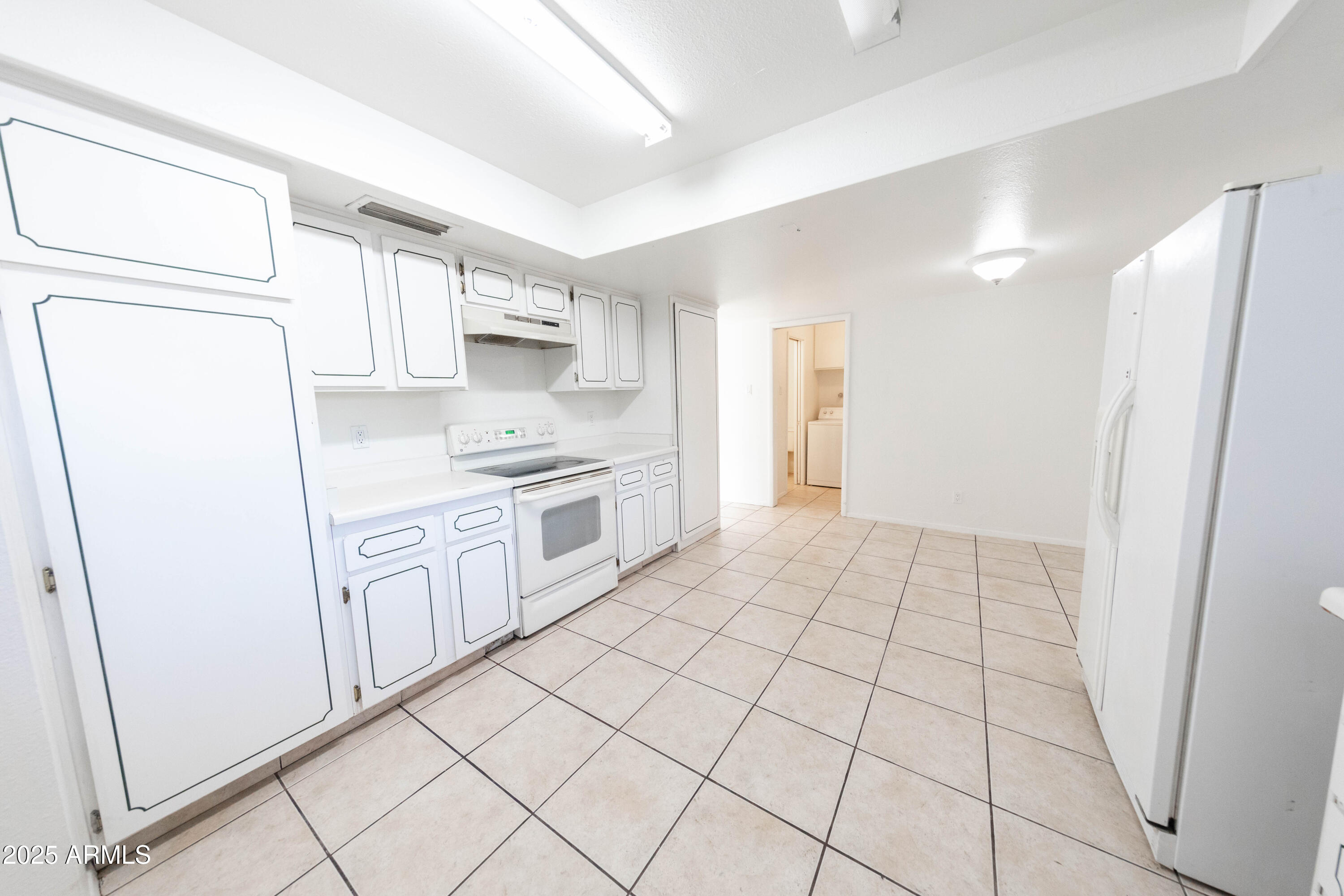 1349 East Donner Drive Tempe, AZ 85282 - Photo 4 of 26 a kitchen with white cabinets and white appliances