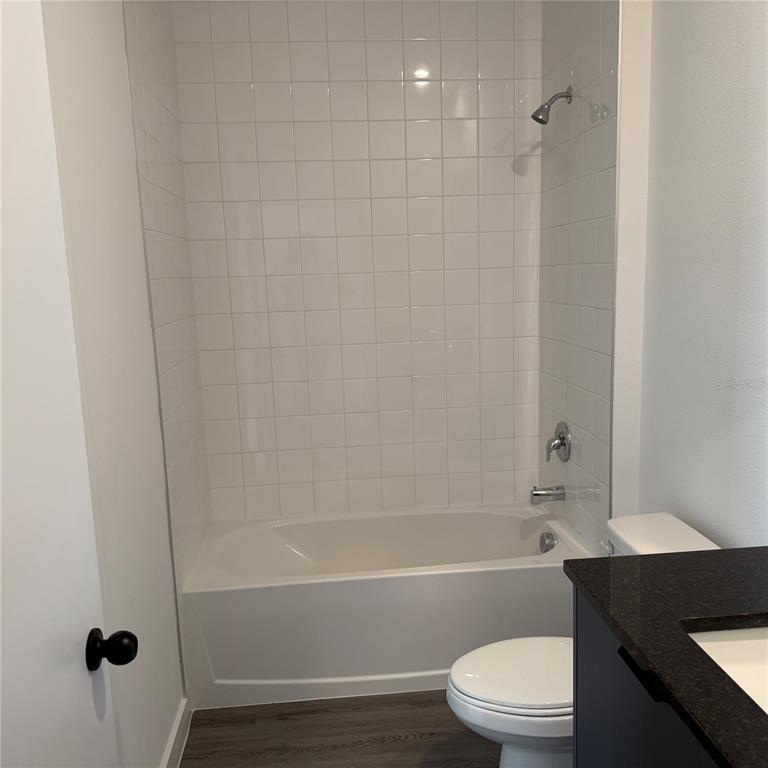 3245 Sustainable Way Kissimmee, FL 34747 - Photo 12 of 35 a bathroom with a bathtub shower sink vanity and a toilet